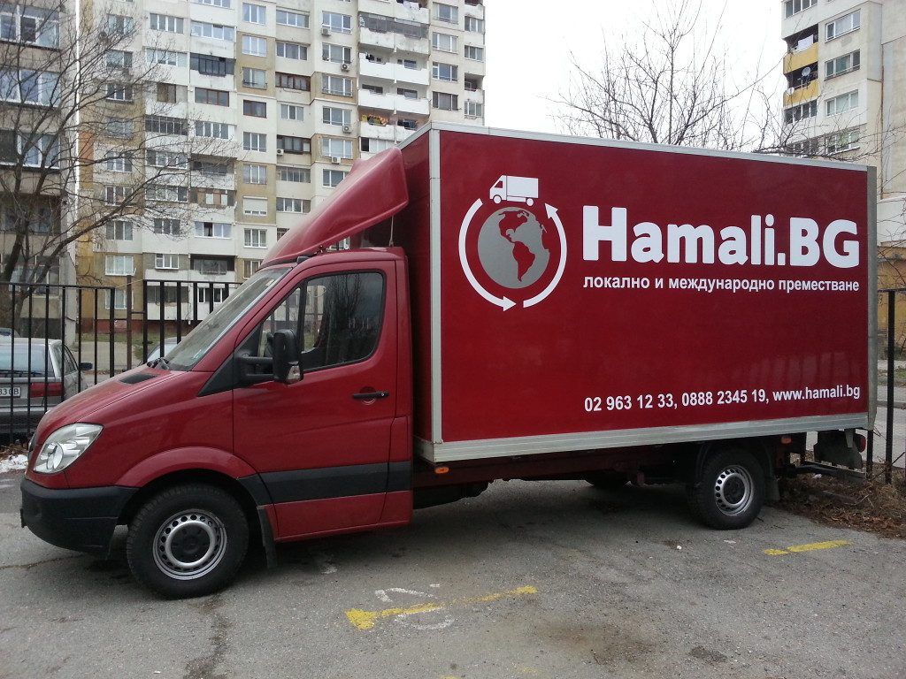 Un camion de déménagement Hamali.BG garé dans une rue résidentielle
