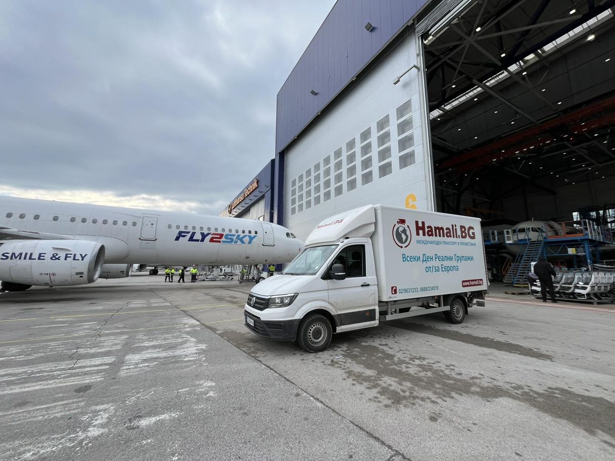 Un camion Hamali.BG sur le tarmac, à côté d'un avion à l'aéroport